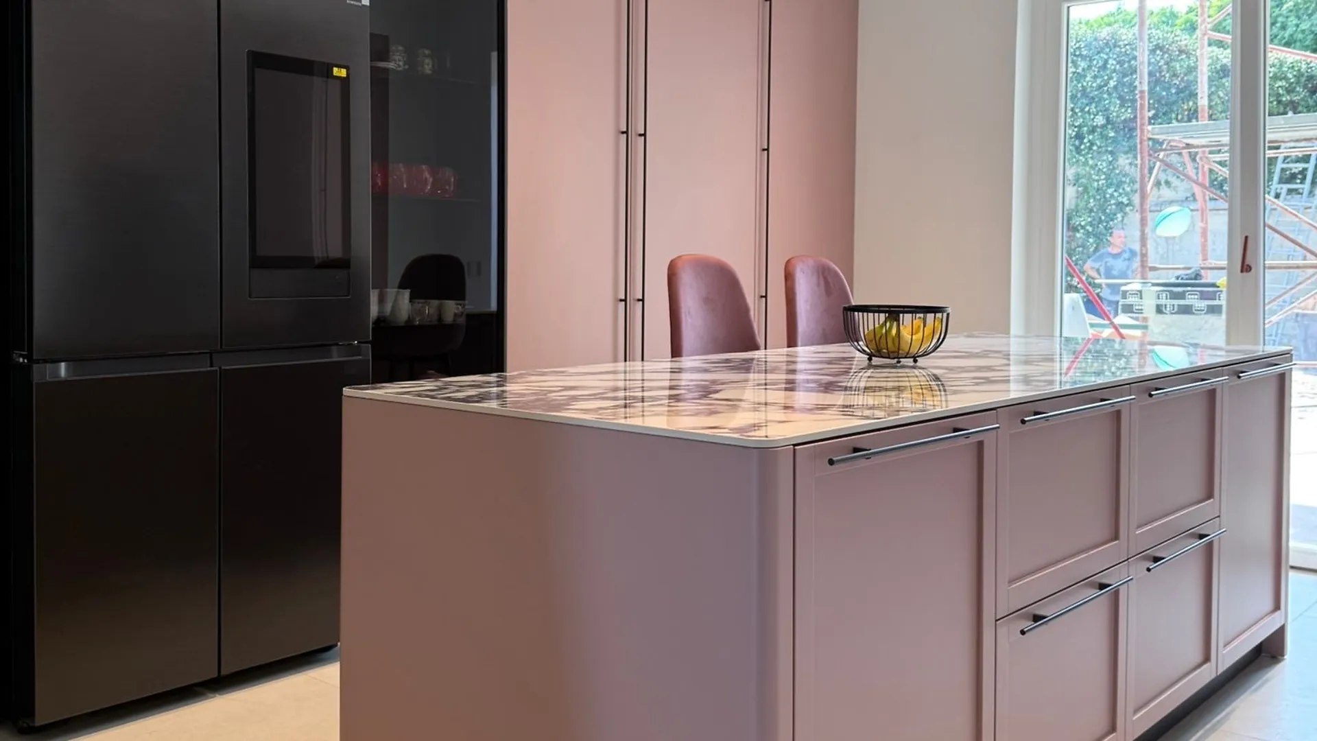 Cucina realizzata: isola rosa antico con top in marmo Calacatta viola, colonne e frigorifero nero